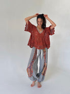 woman wearing a rust knit short sleeve top and grey jogger pants