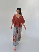 woman wearing a rust top with charcoal jogger pants