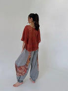 woman wearing outfit with rust knit top and charcoal jogger pants from the back