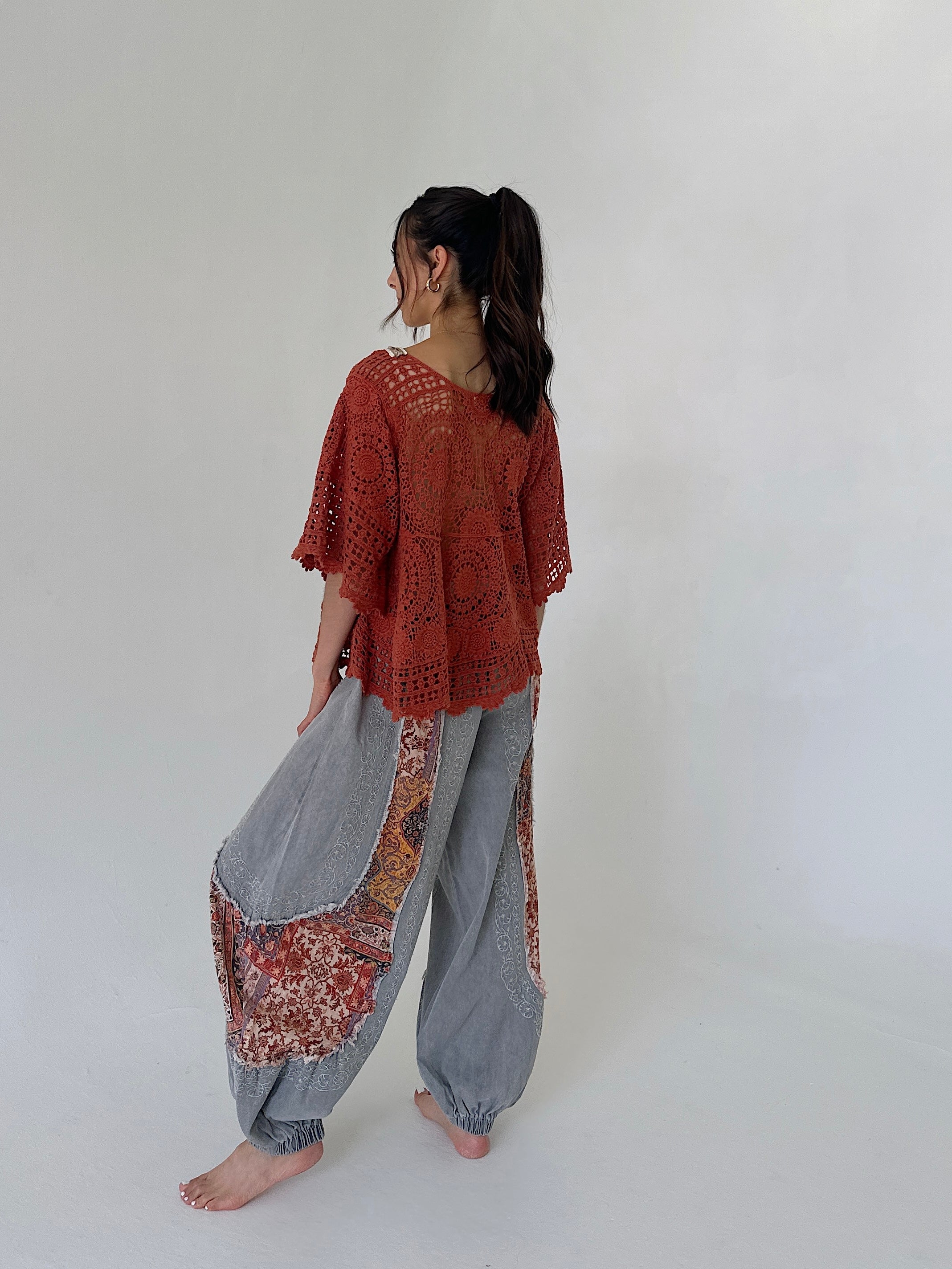 woman wearing outfit with rust knit top and charcoal jogger pants from the back
