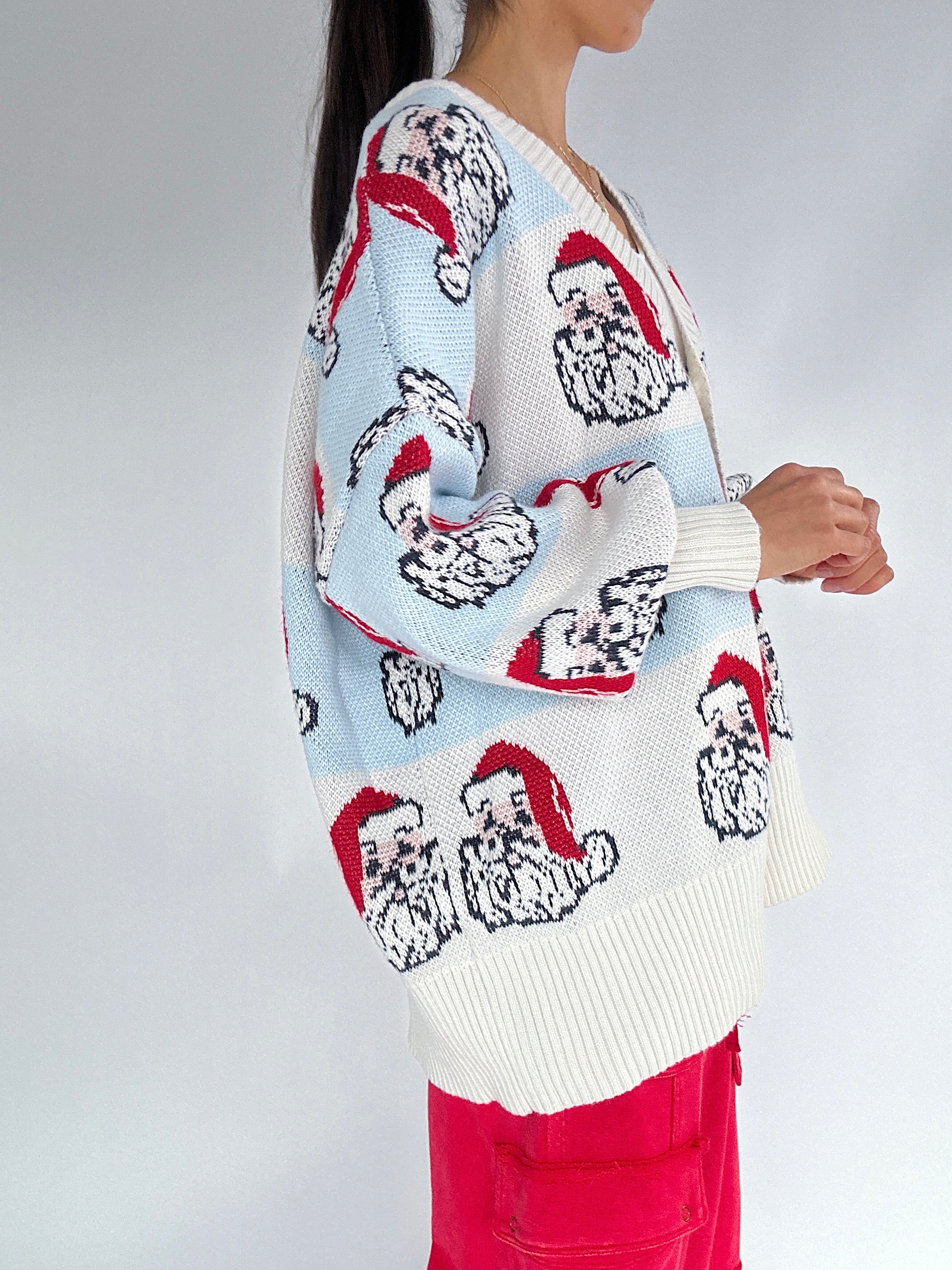 Person wearing a patterned sweater with cartoon characters on a plain background side view