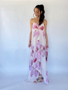 Woman wearing a floral strapless dress against a white background