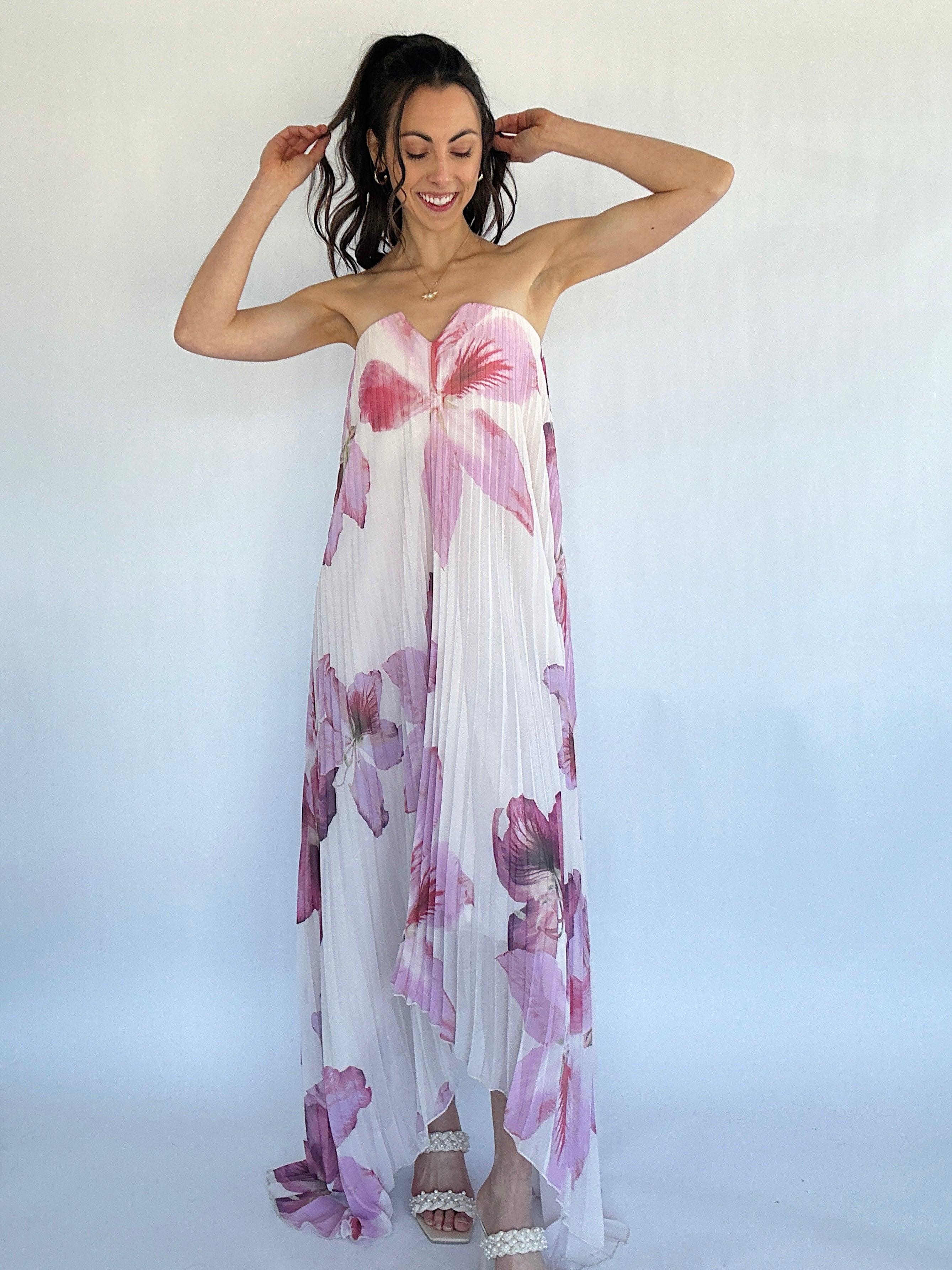 Woman wearing a floral strapless dress against a white background