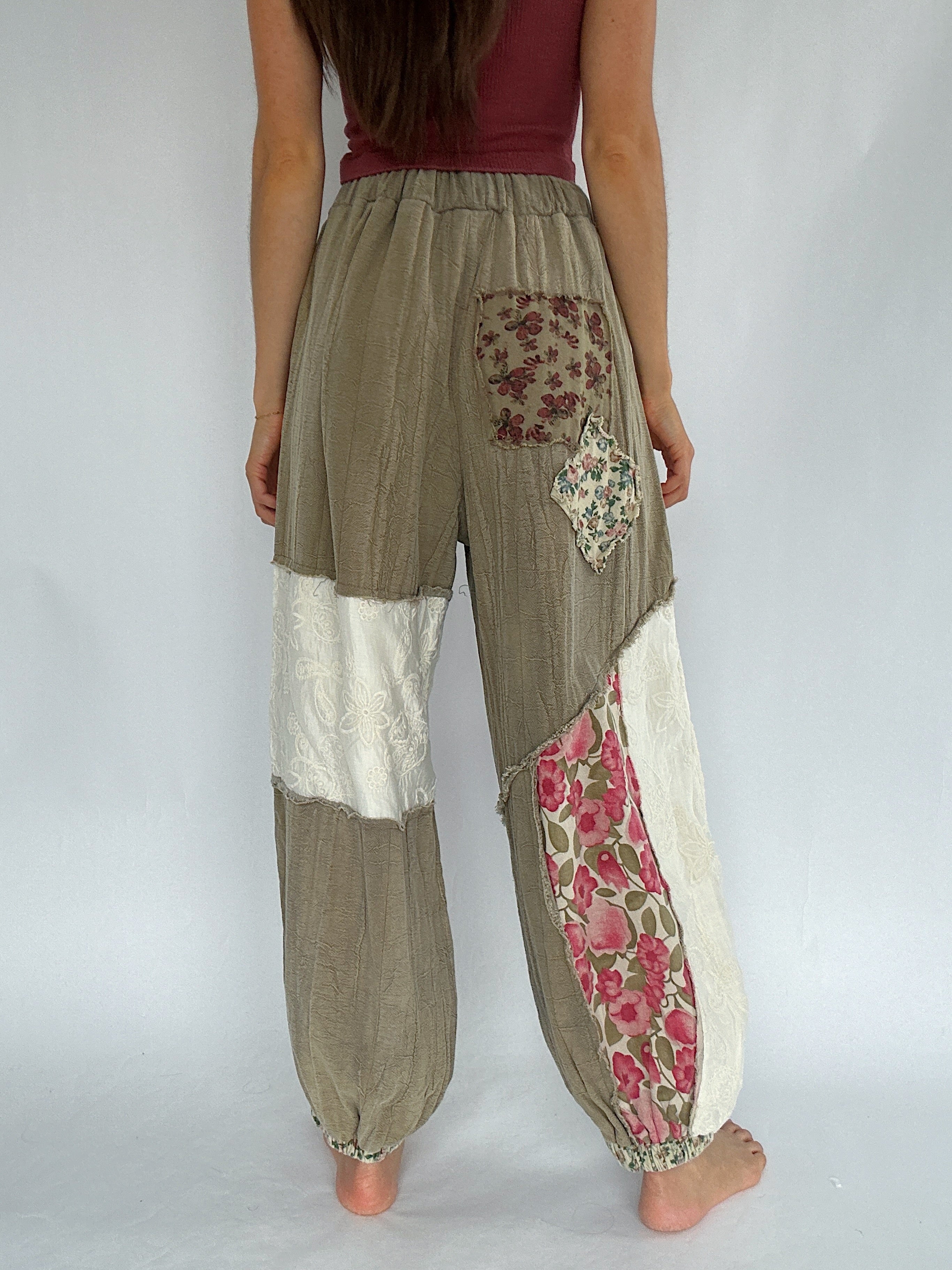 Patchwork pants with floral and lace patterns on a plain background showing back