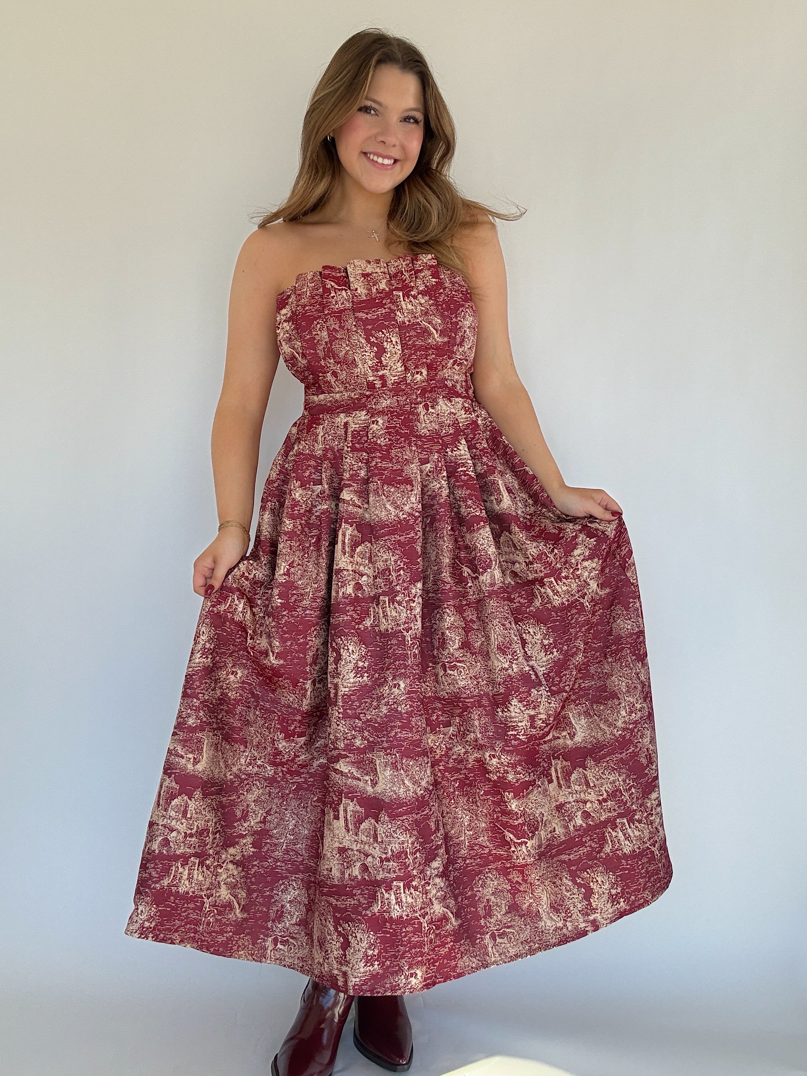Woman wearing a strapless dress with a floral pattern against a plain background