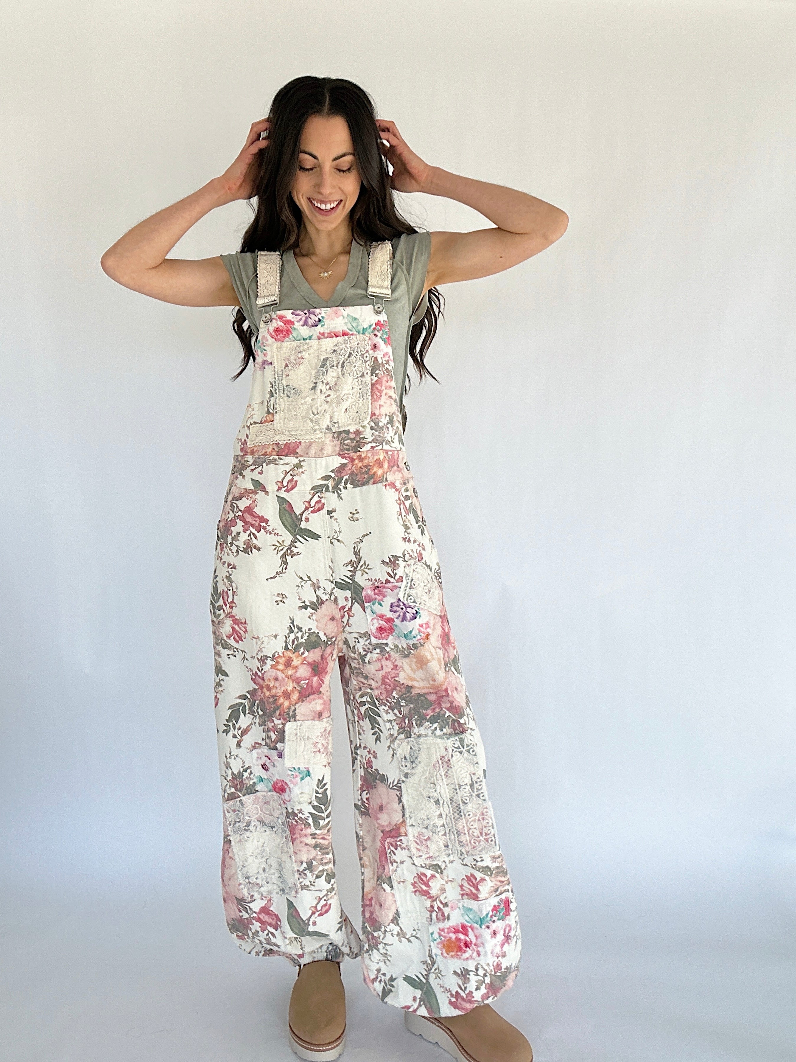 Woman wearing a floral overalls with a plain background