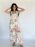Woman wearing a floral overalls with a plain background