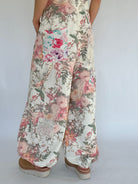 Floral patterned overalls worn by a person on a white background showing leg details