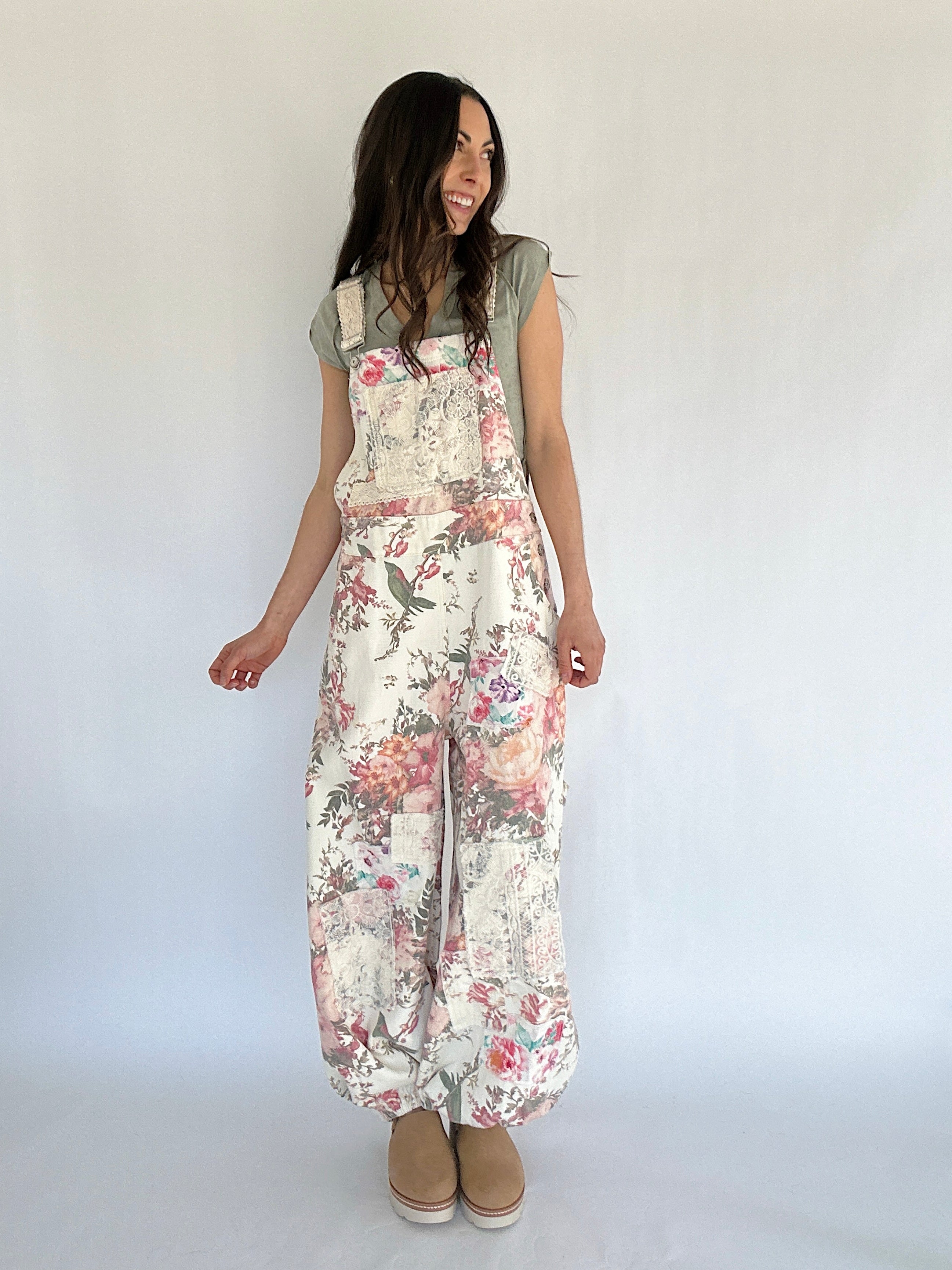 Woman wearing floral overalls against a white background
