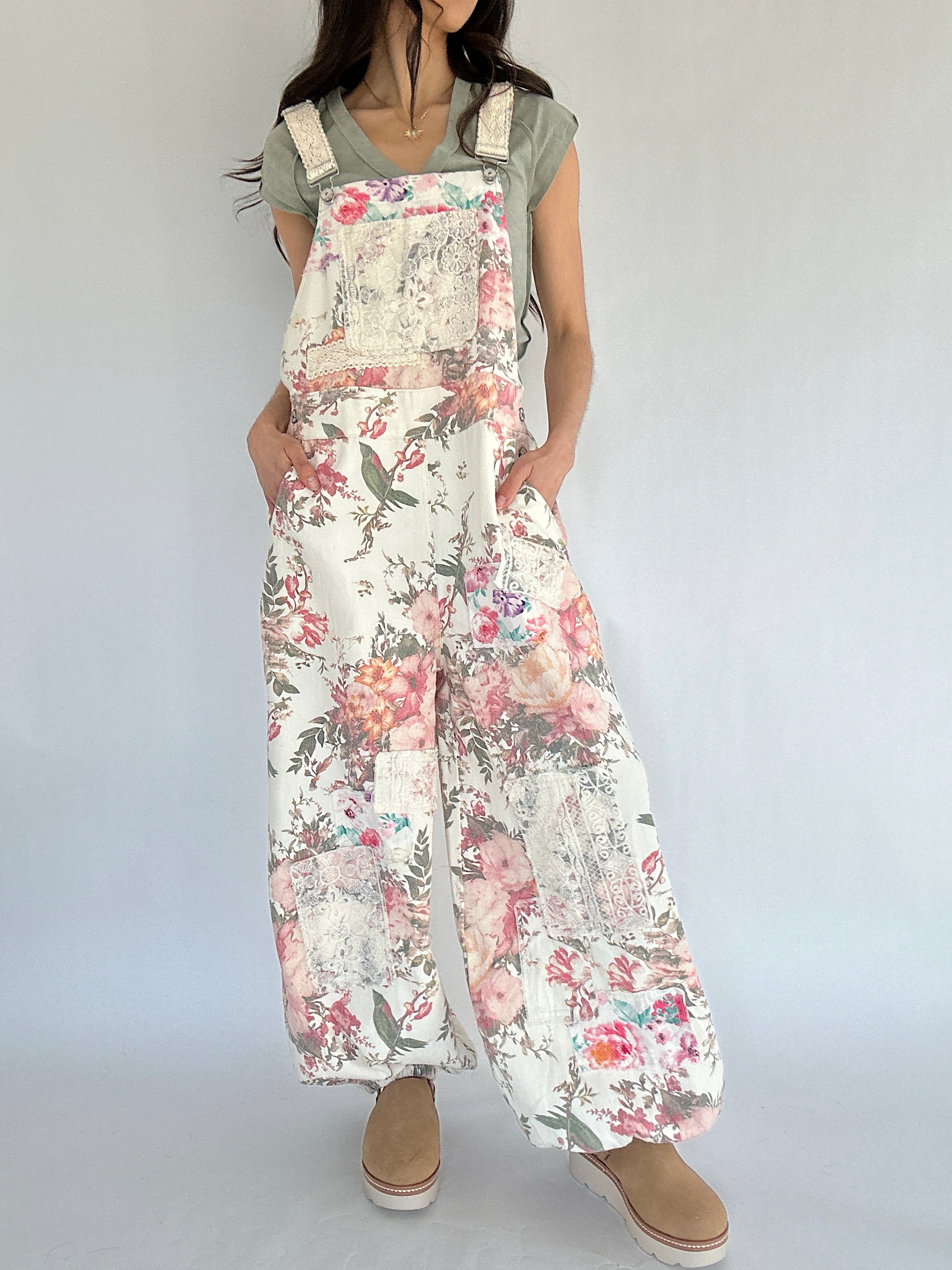 Person wearing floral overalls on a plain background
