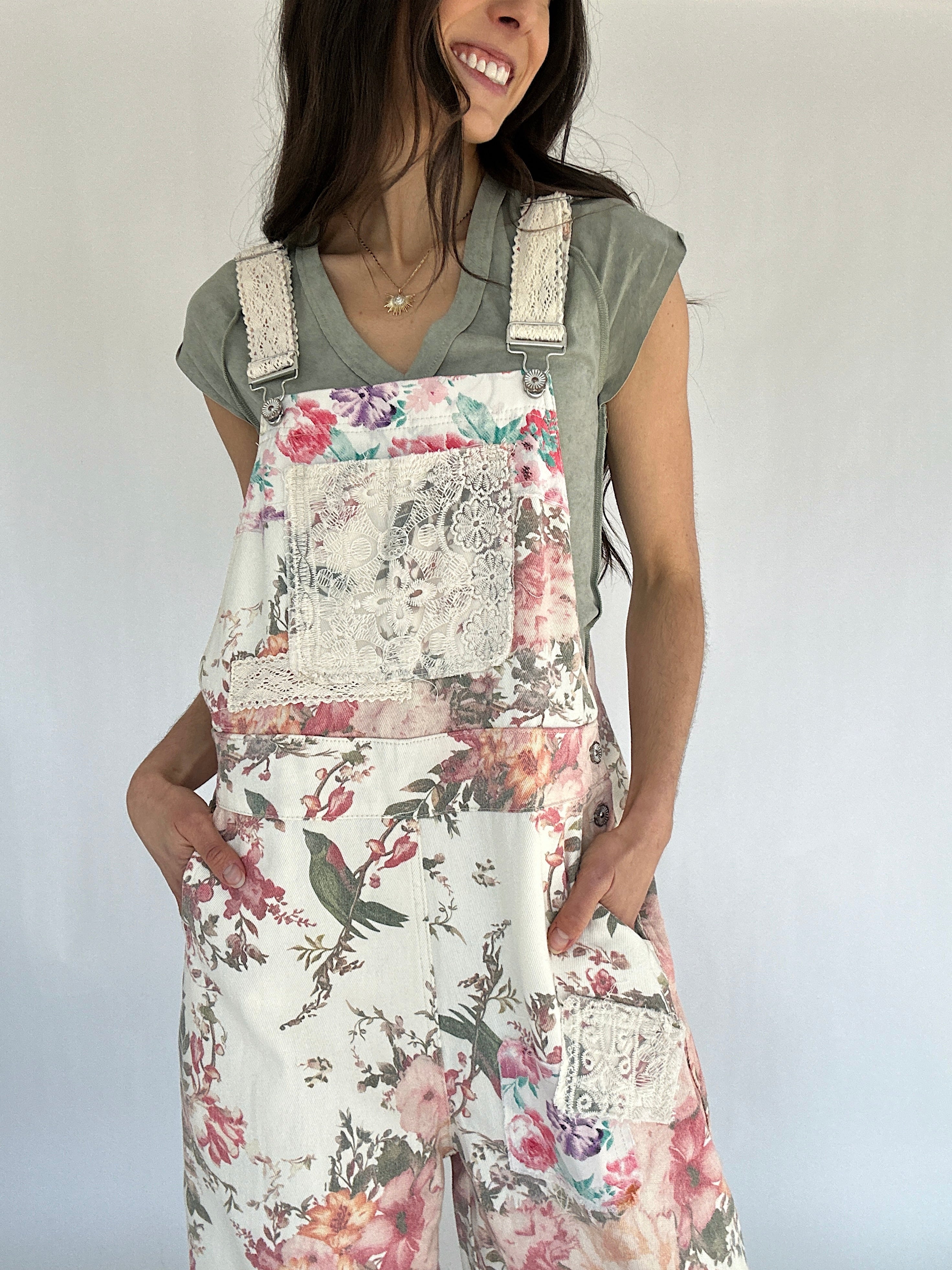 Woman wearing a floral patchwork overalls with a plain background