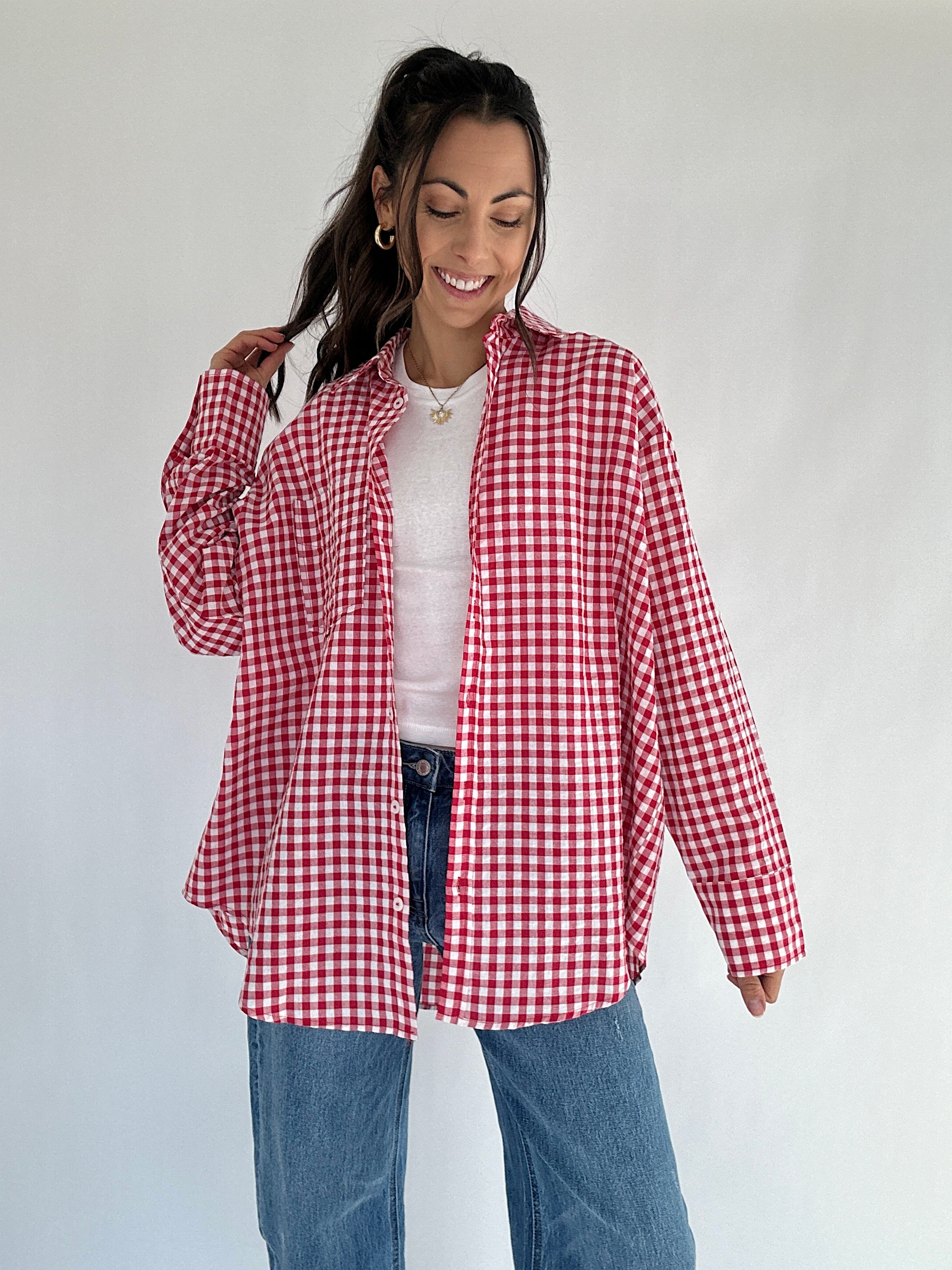Woman wearing a red and white checkered shirt against a plain background