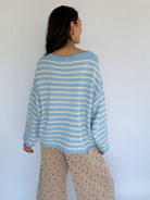 Person wearing a blue and white striped sweater against a white background