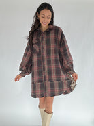 Woman wearing a plaid dress with a plain background