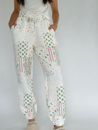 White holiday patterned quilted jogger pants worn by a person on a plain background