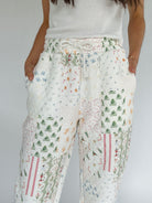 Holiday patterned pants worn by a person on a plain background showing elastic and drawstring waist