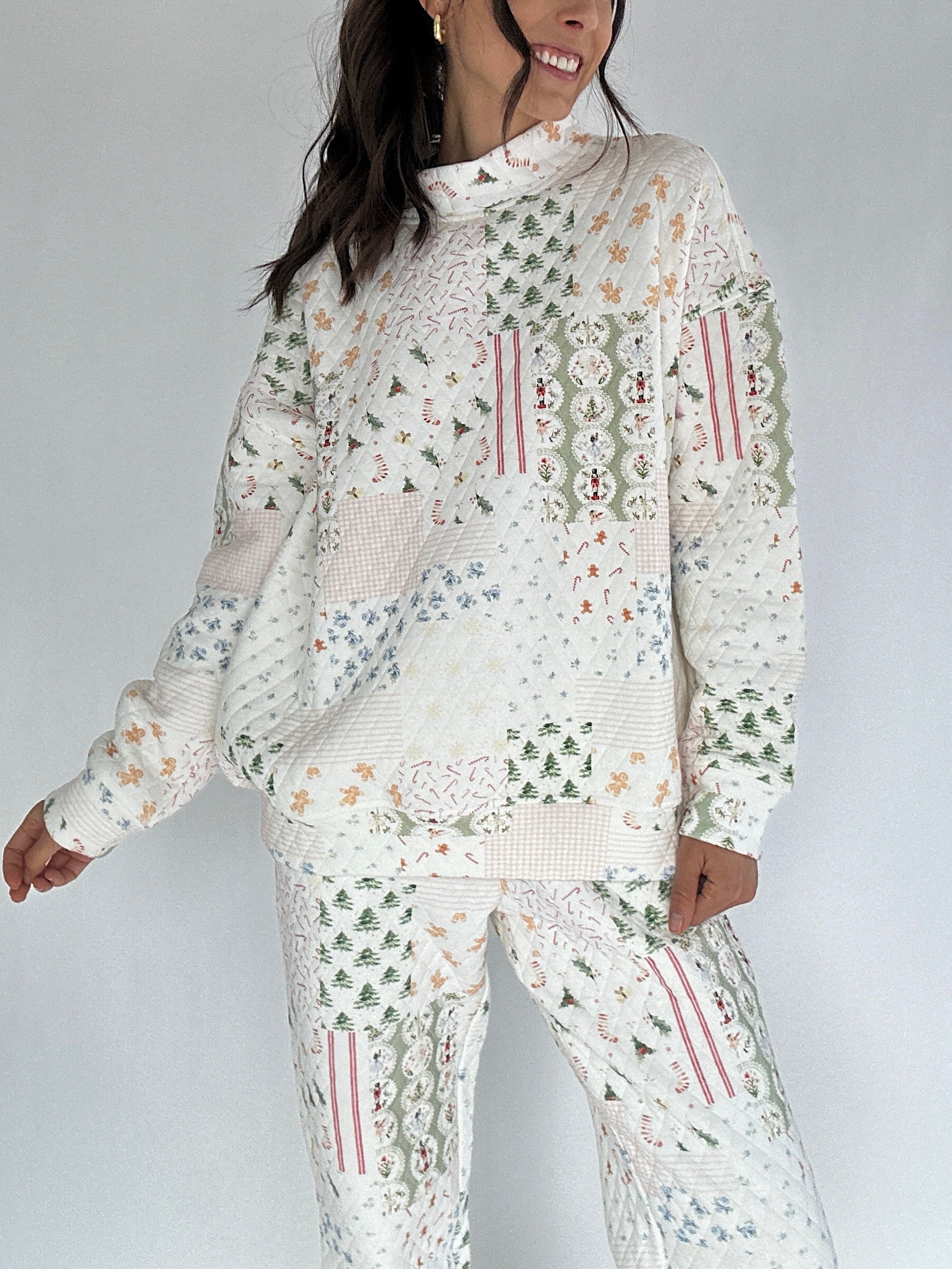 Person wearing a white quilted outfit with holiday patterns on a plain background