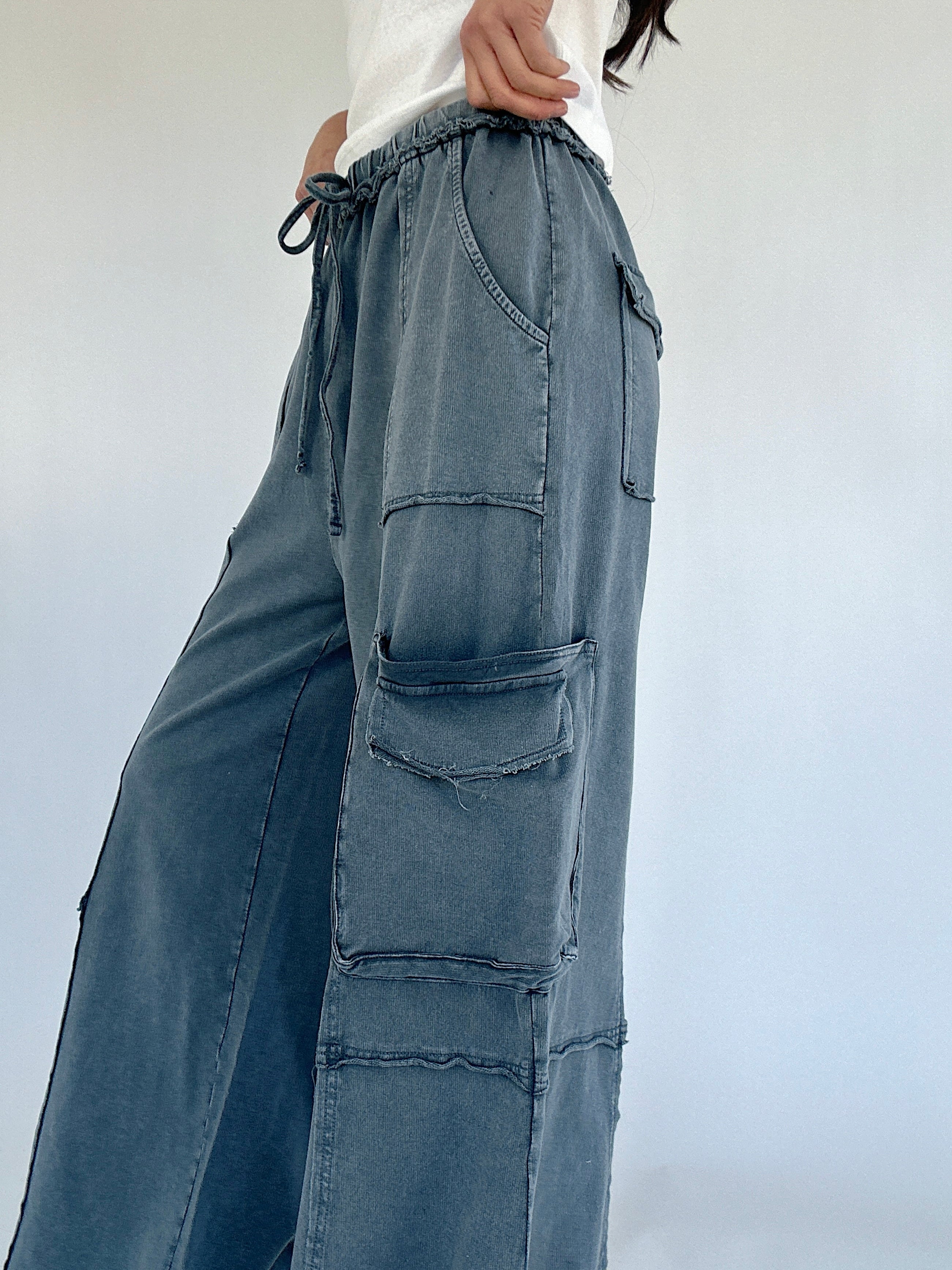 Smoke blue cargo pants with multiple pockets on a plain background