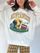 Person wearing a white sweatshirt with West Virginia Mountaineers football graphic design.