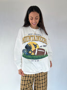 Woman wearing a West Virginia Mountaineers sweatshirt with a graphic design on a plain background