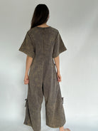 Person wearing a brown jumpsuit against a plain background to show back zip up feature