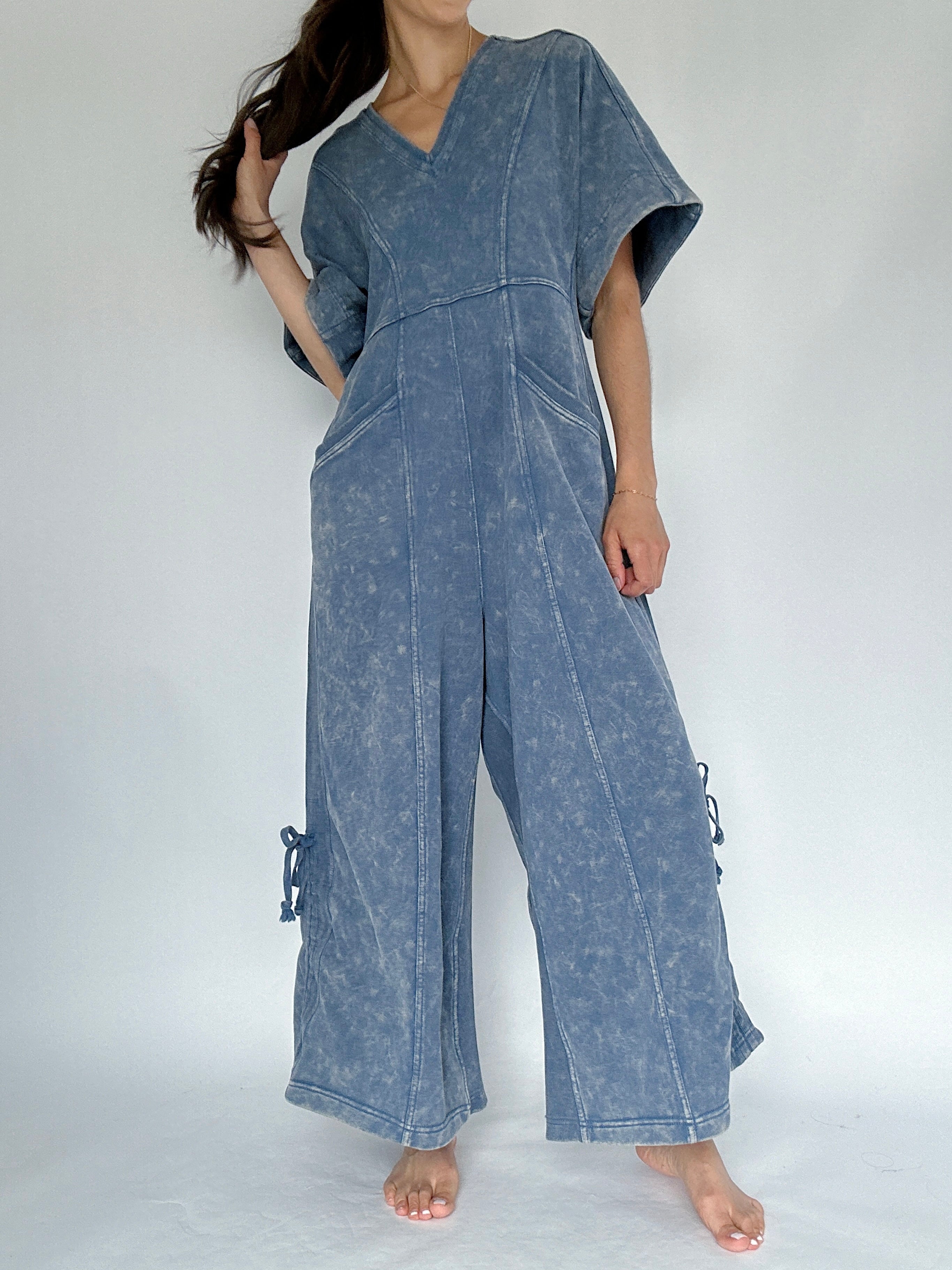 Person wearing a blue denim jumpsuit on a white background