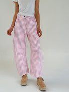Person wearing pink gingham pants on a plain background