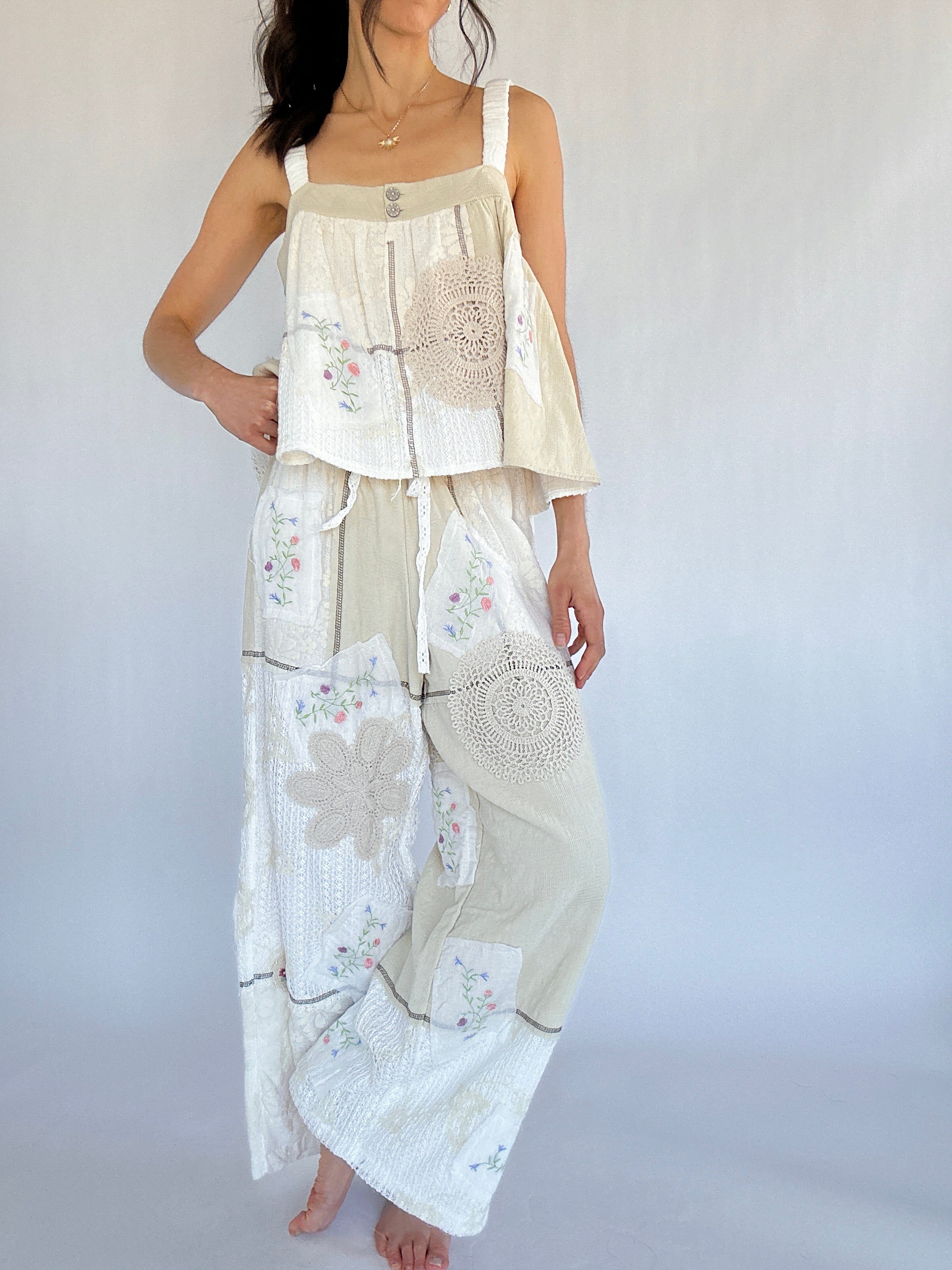Woman wearing a white and beige outfit with floral patterns on a plain background