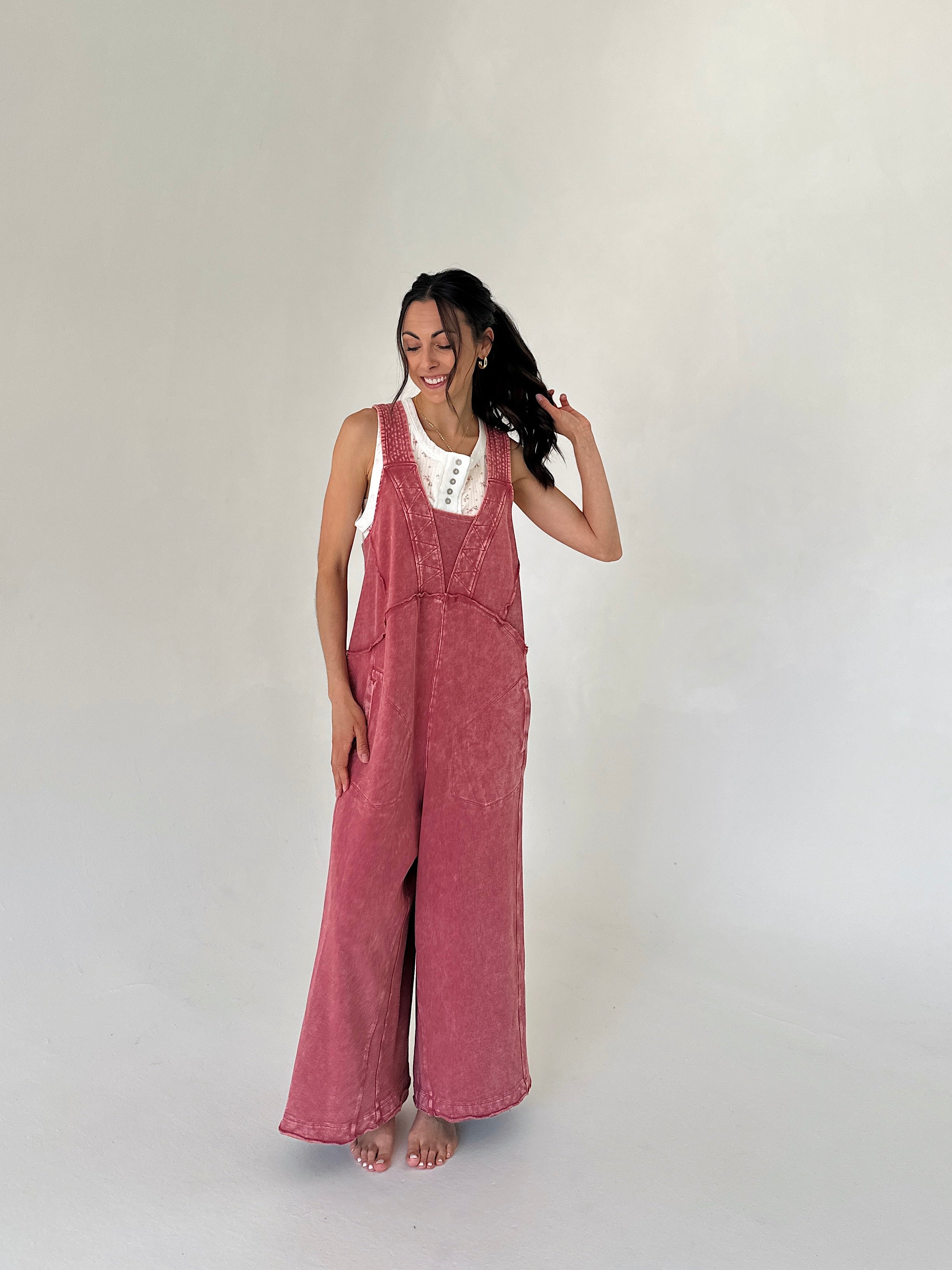 Woman wearing a pink terry overalls on a plain background