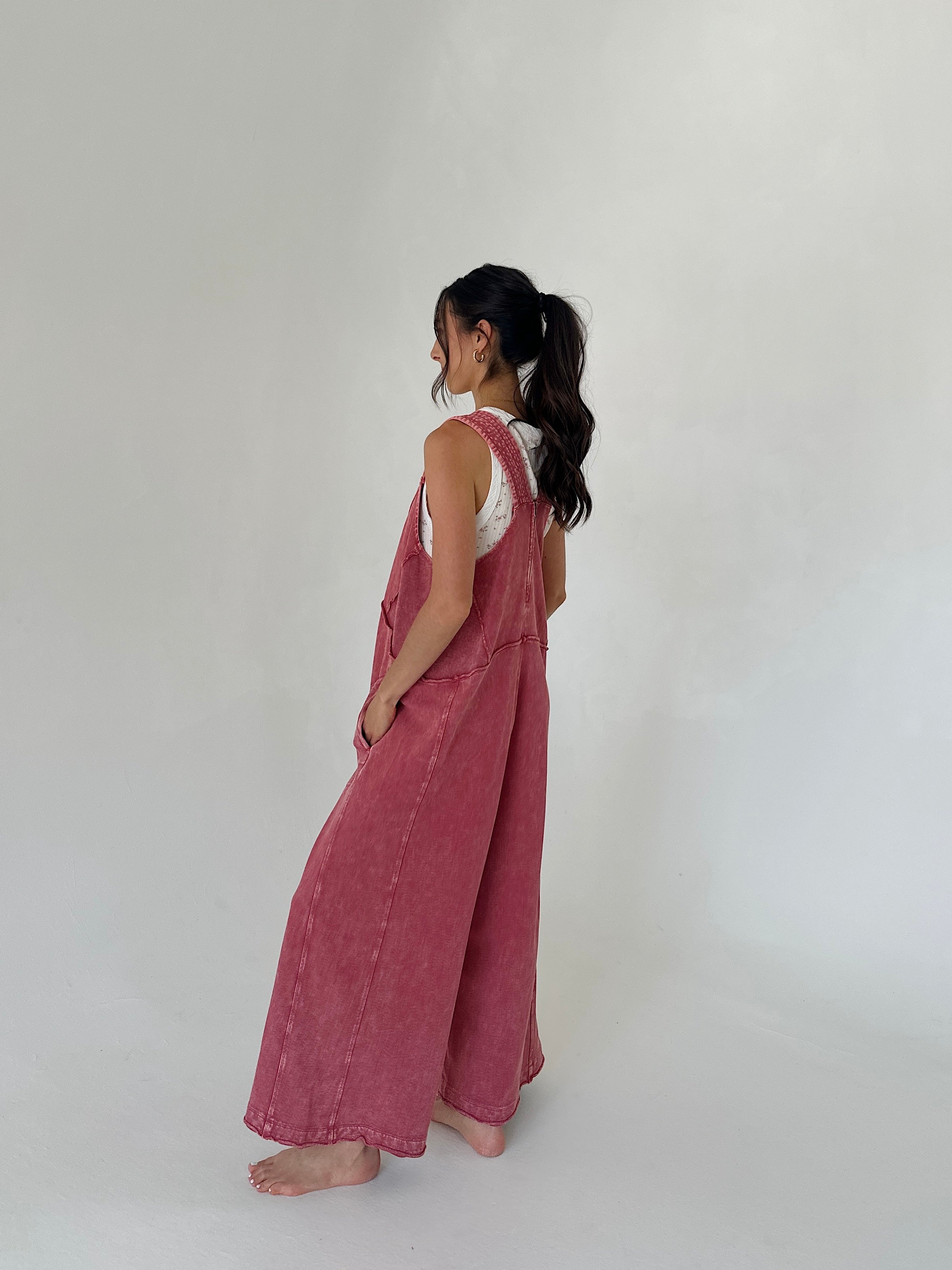 Woman wearing a pink jumpsuit against a white background