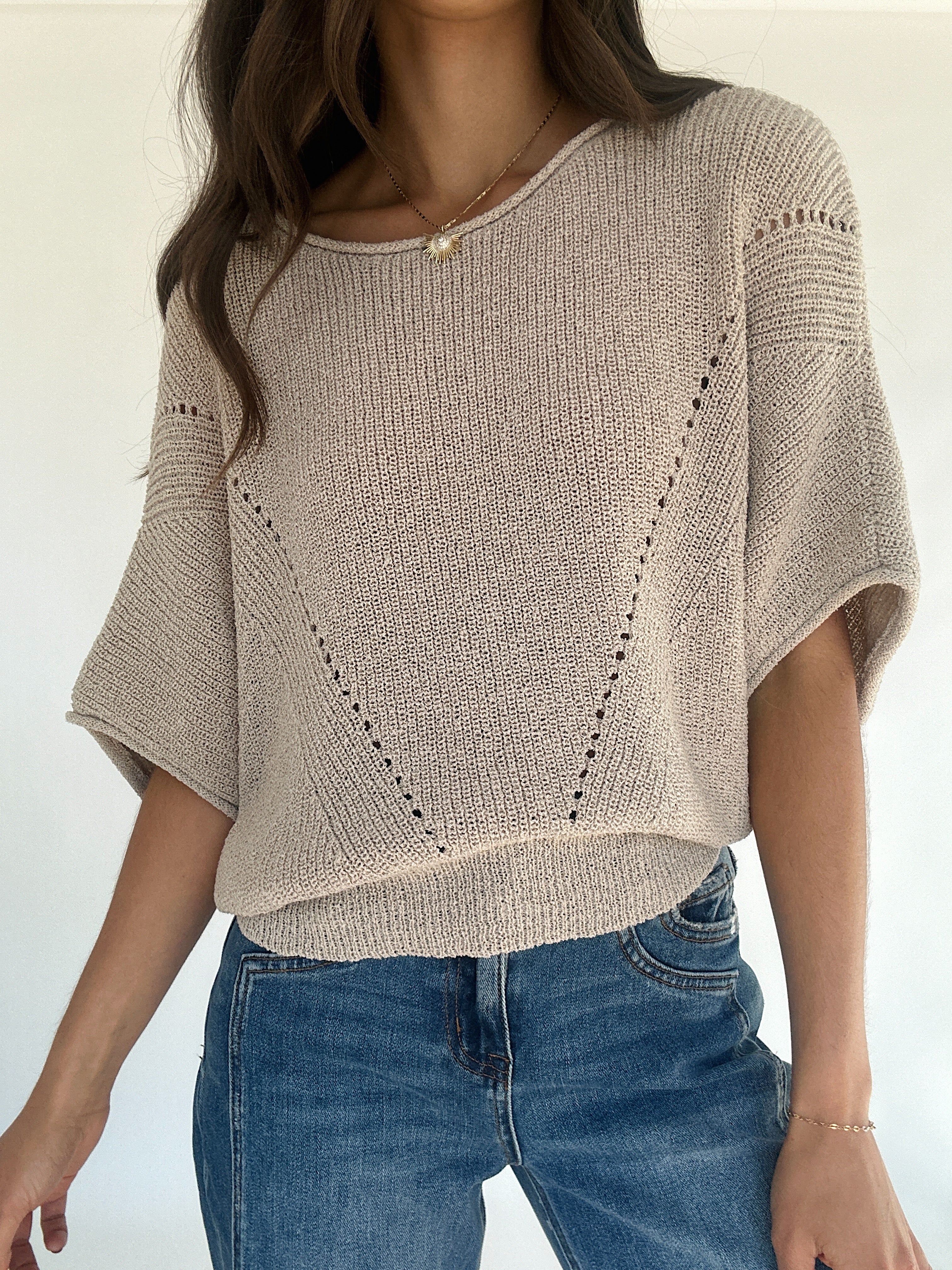 Oatmeal knit sweater with 3/4 sleeves with jeans on a white background