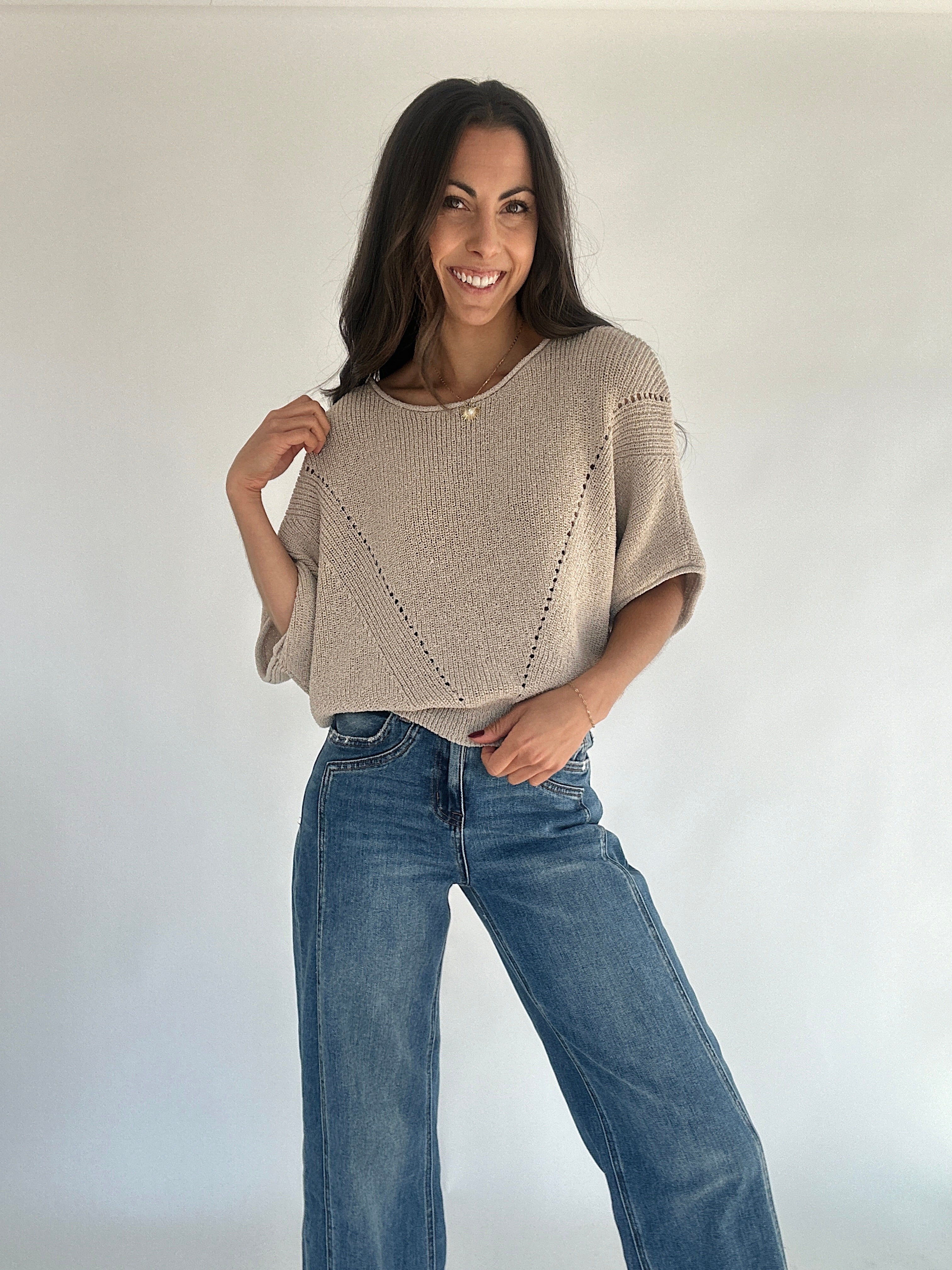 Woman wearing oatmeal sweater with jeans