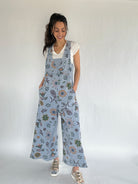 Woman wearing floral jumpsuit against a plain background