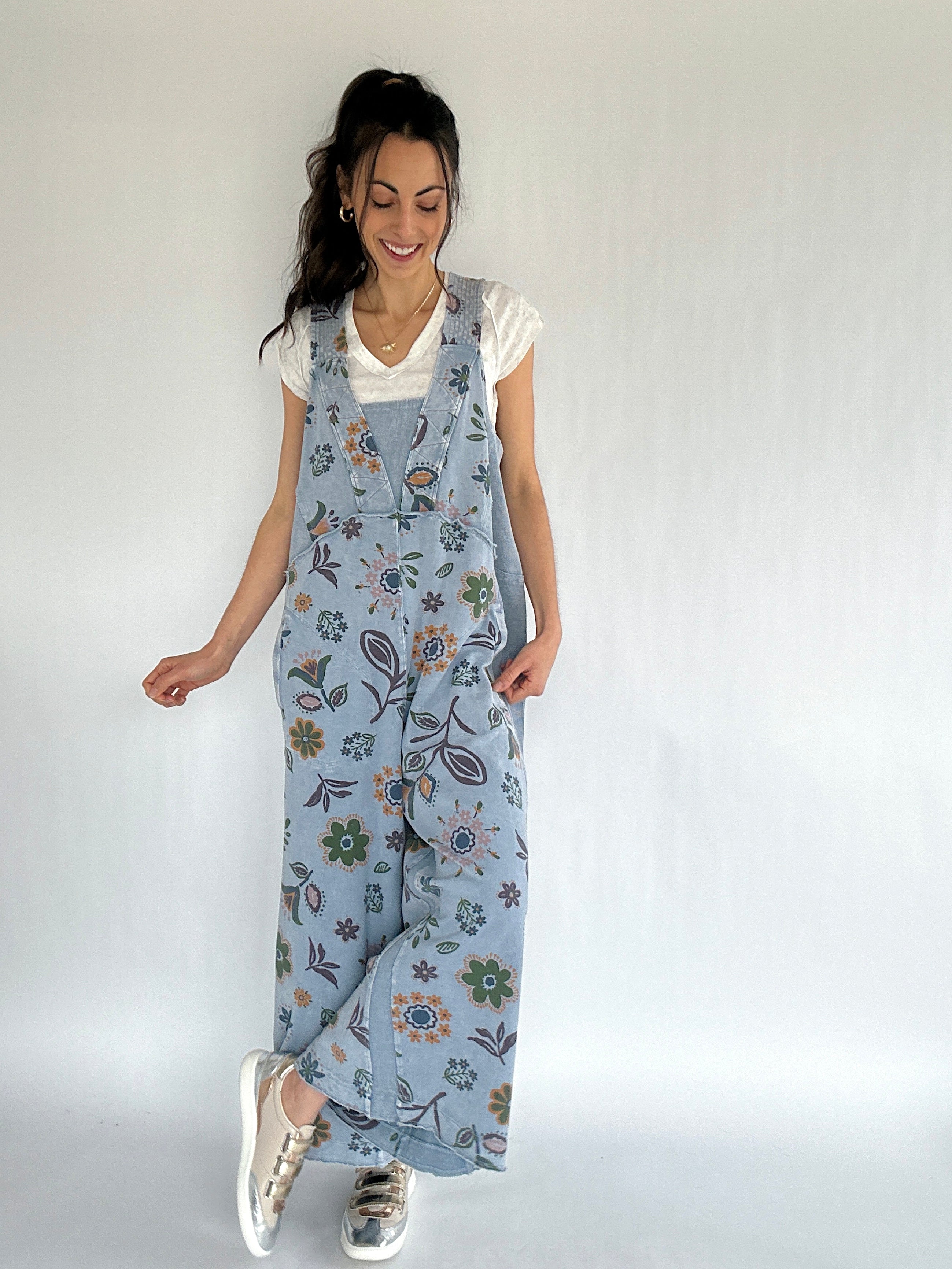 Woman wearing a floral overall jumper against a white background