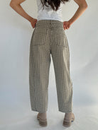 Person wearing plaid pants on a plain background to show back pockets