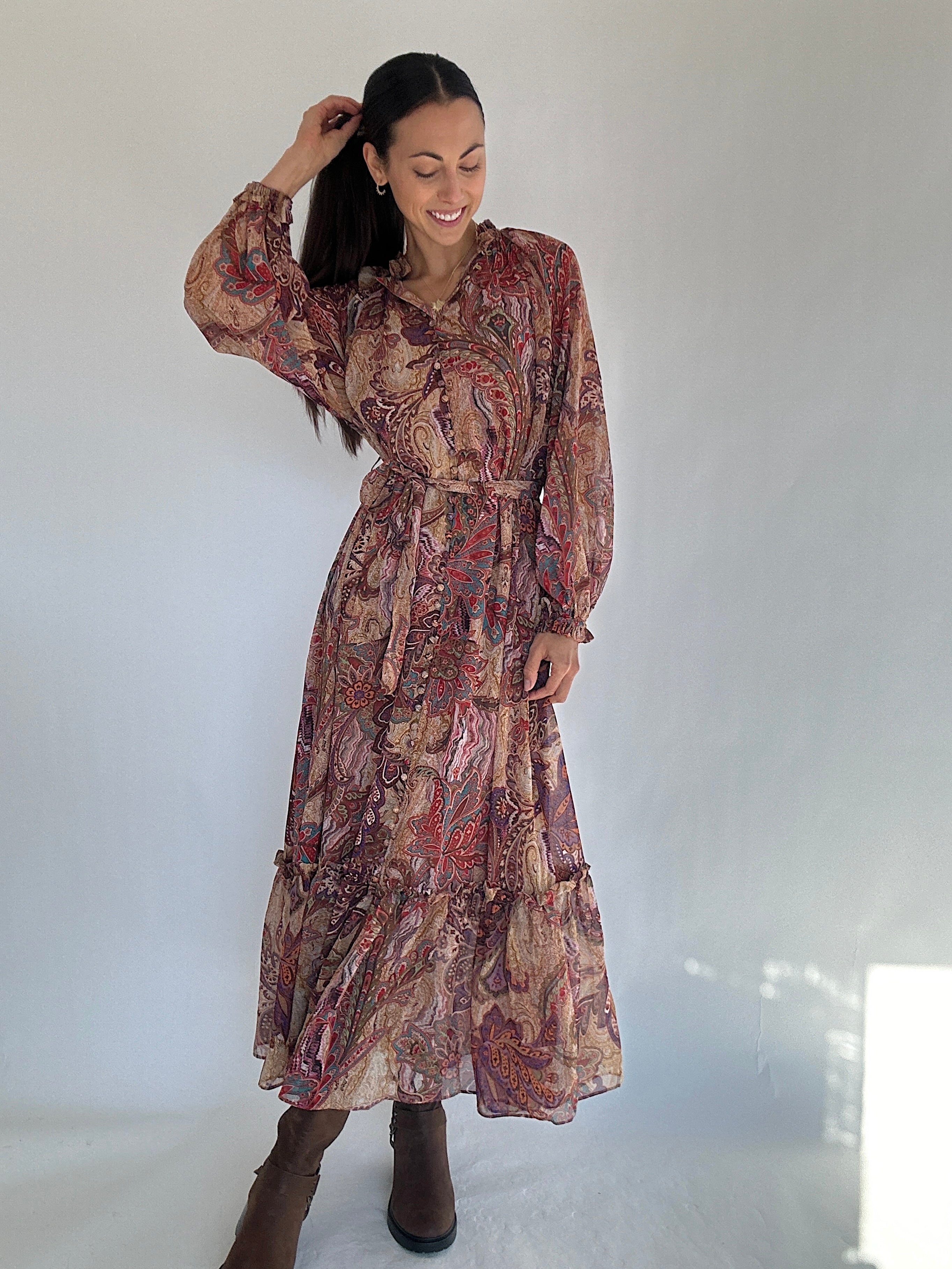 Woman wearing a boho paisley patterned dress against a white background