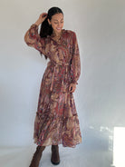 Woman wearing a boho paisley patterned dress against a white background