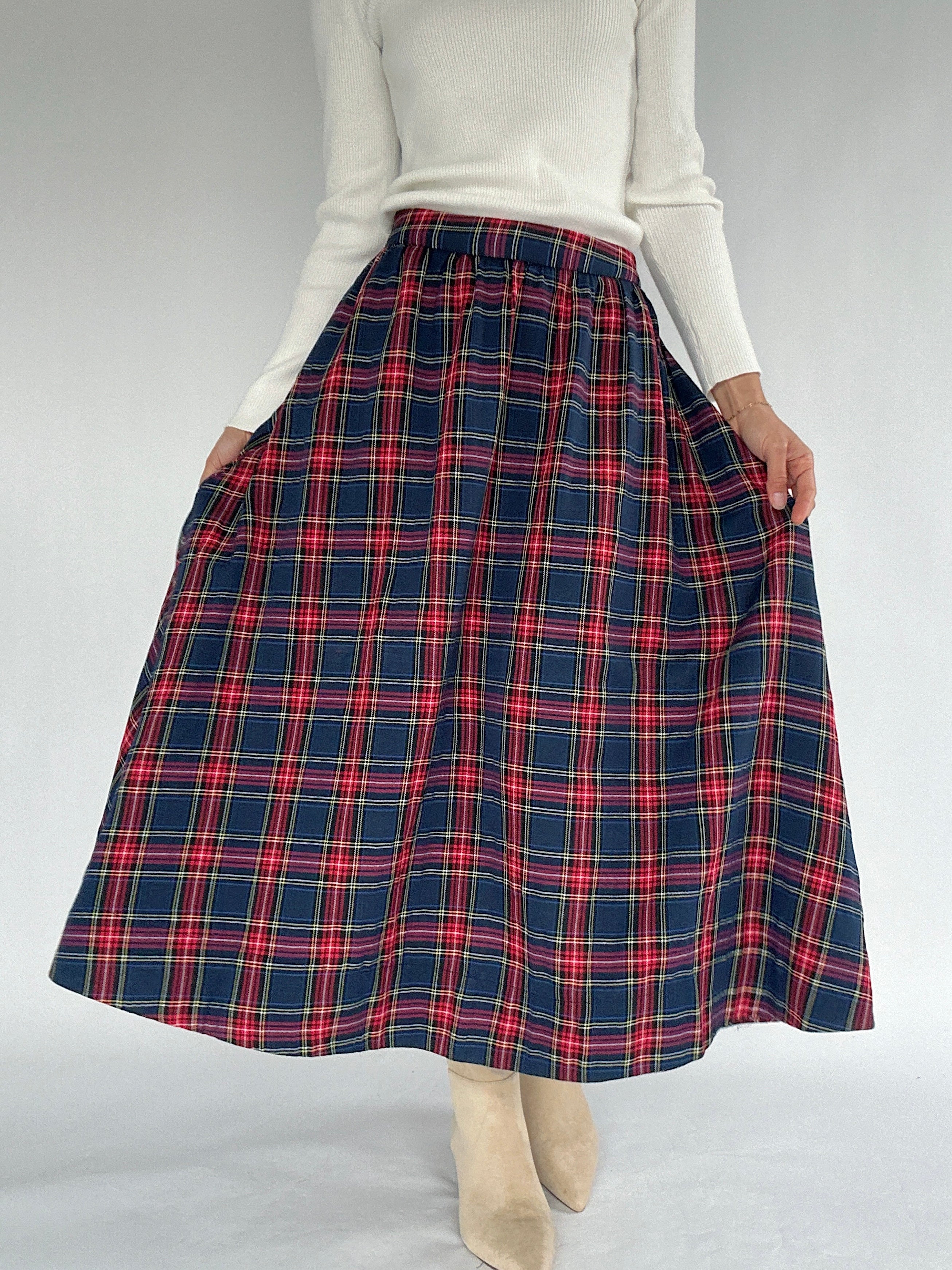 Person wearing a red and blue plaid skirt on a white background