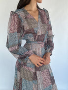 Patchwork patterned dress worn by a person against a plain background showing the long bubble sleeve with ruffle detail