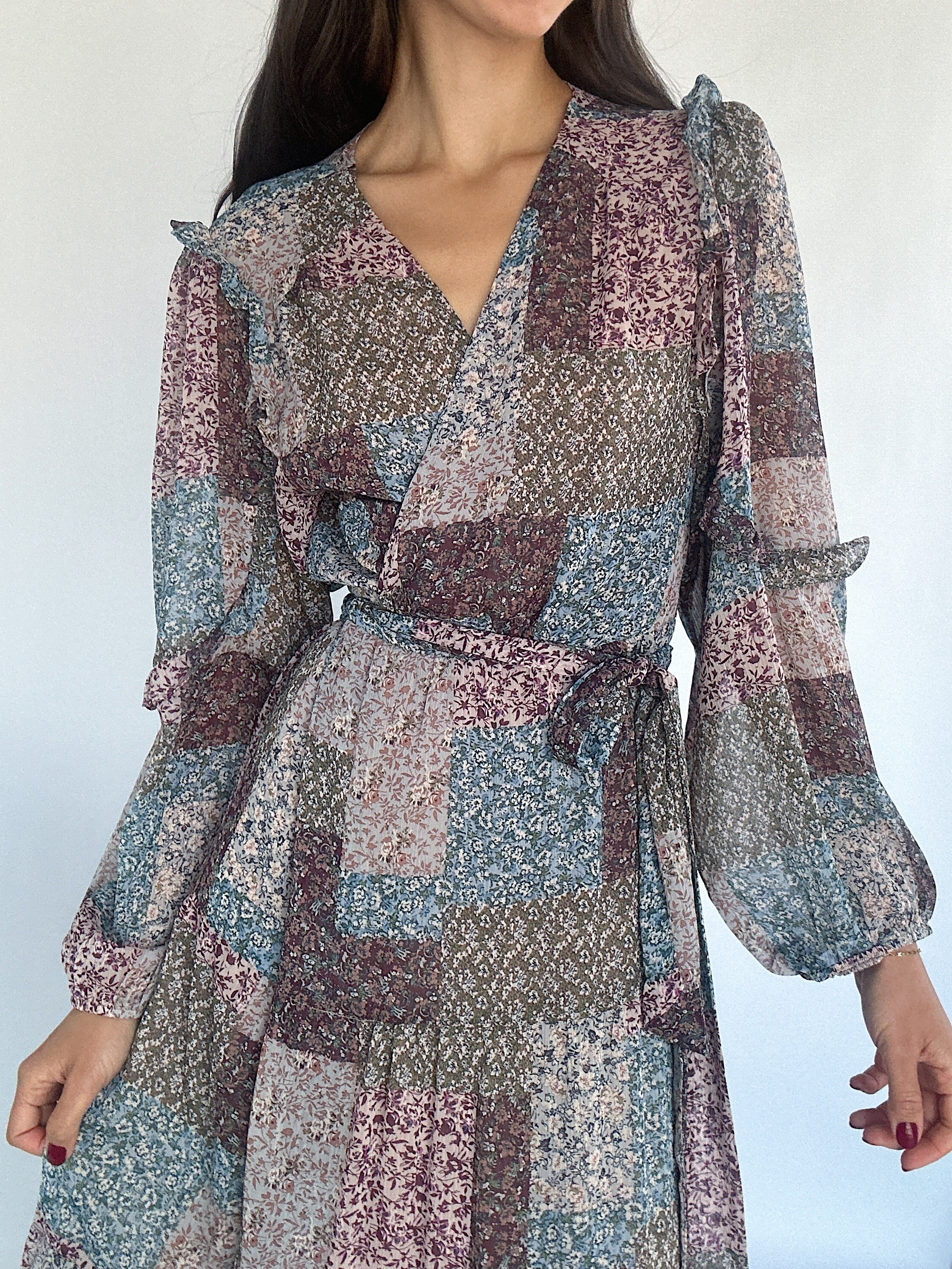 Patterned dress worn by a person on a plain background showing the v-neckline and tie waist