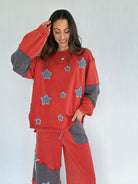 Woman wearing a red and gray outfit with star patches on a white background