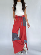 Person wearing red and gray patchwork pants on a white background