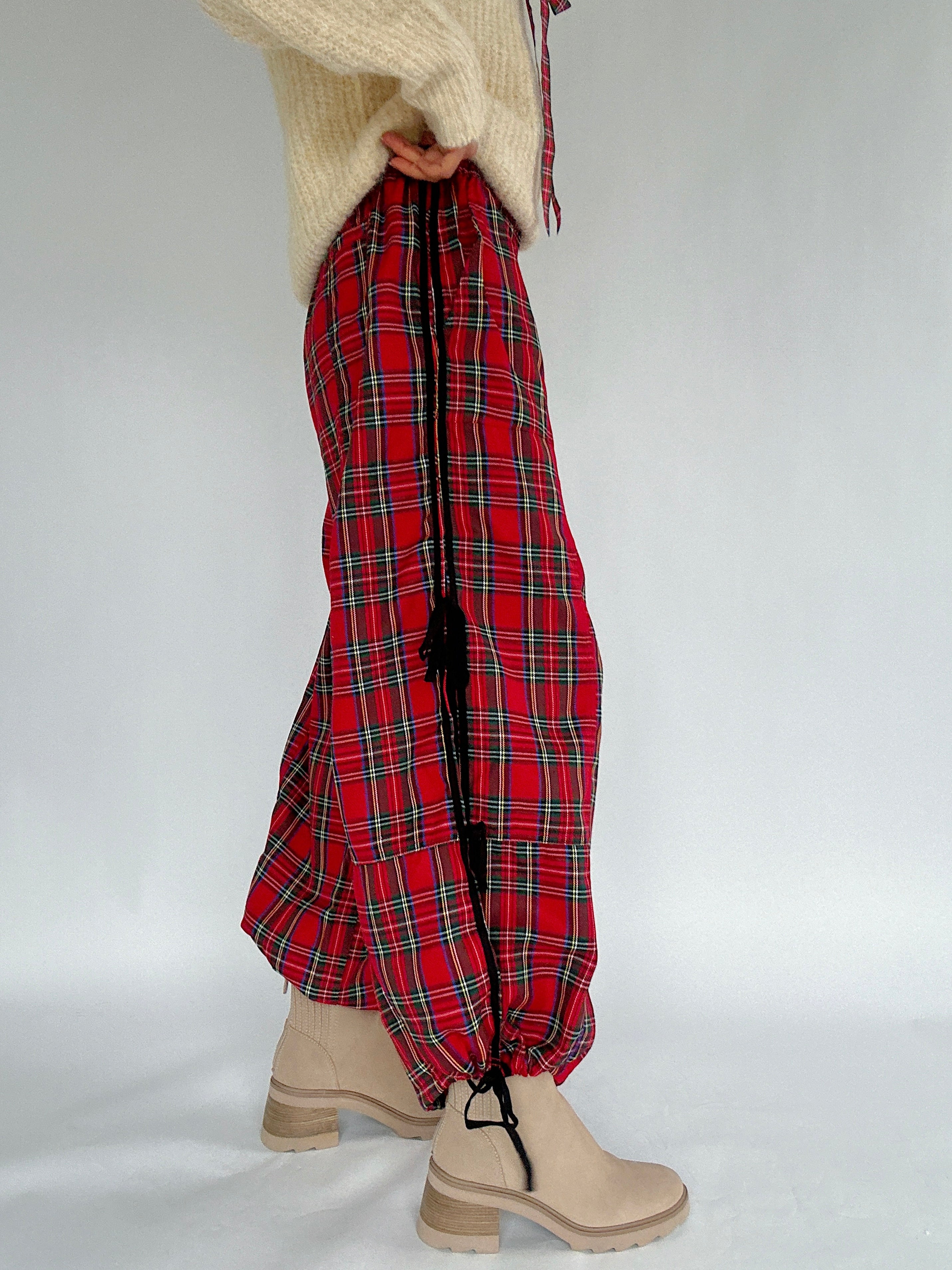 Red plaid pants worn by a person on a white background