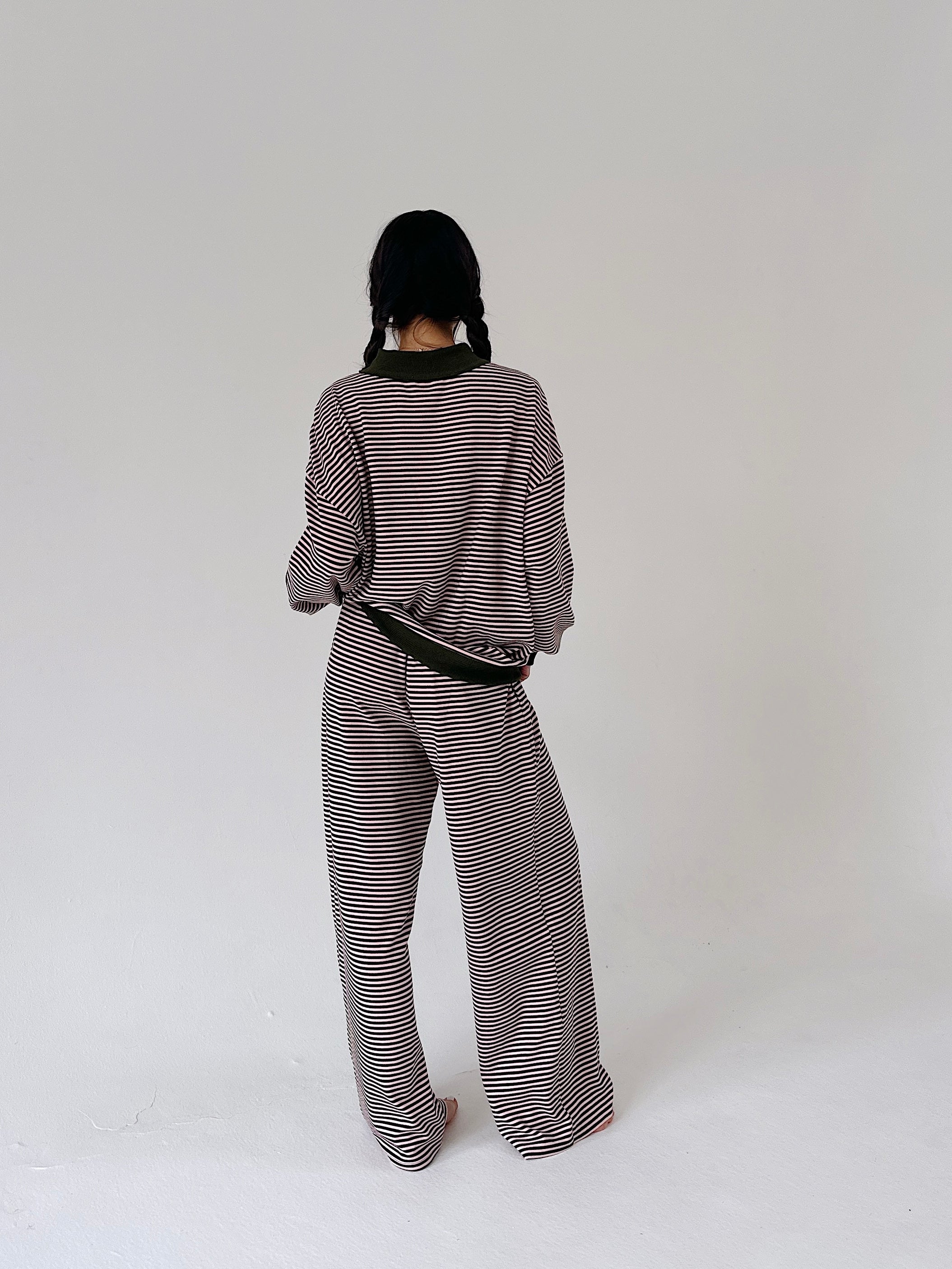 A person shown from the back wearing a matching striped knit top and wide-leg pants set, standing against a plain light gray studio background.