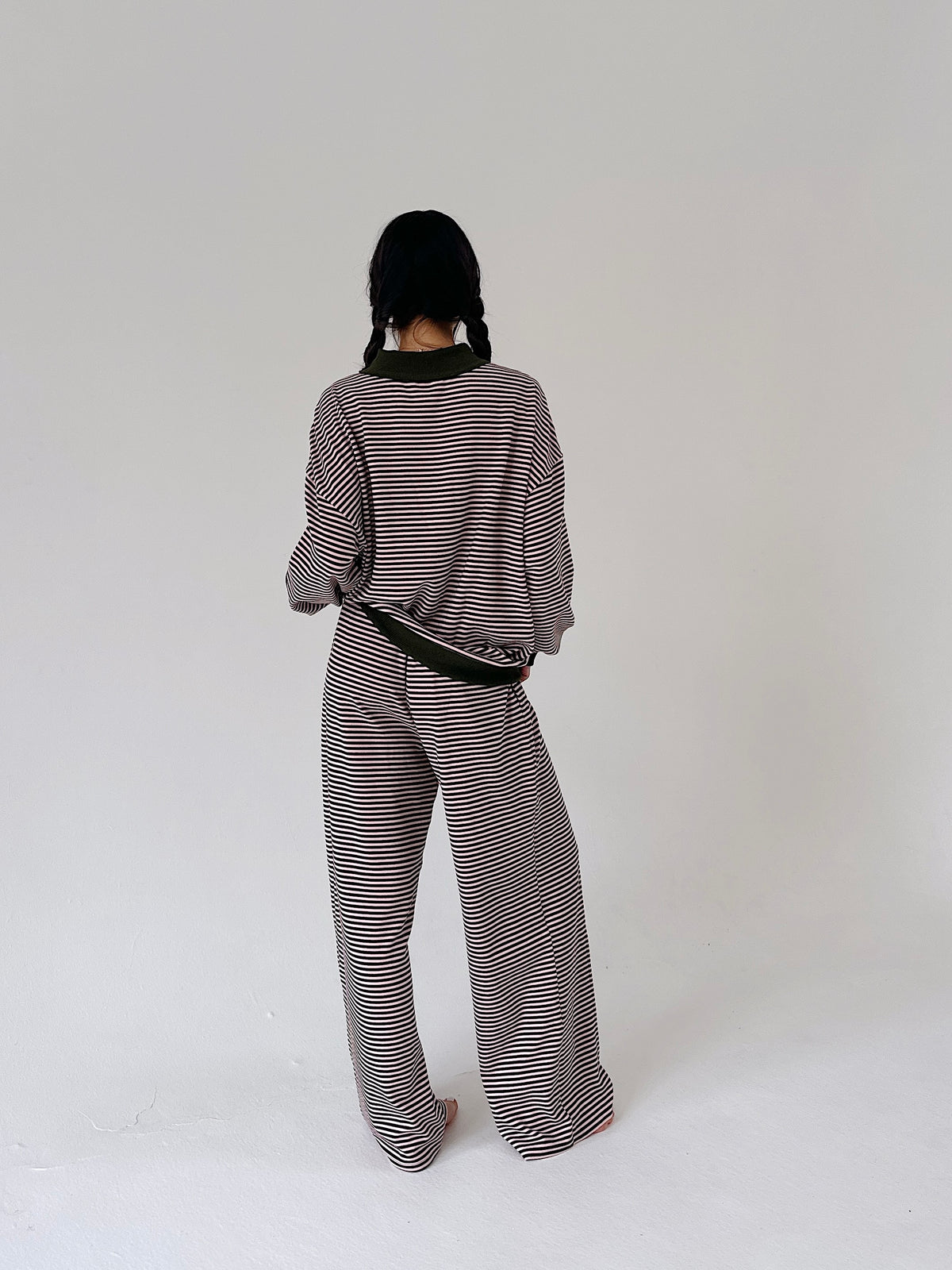 A person shown from the back wearing a matching striped knit top and wide-leg pants set, standing against a plain light gray studio background.
