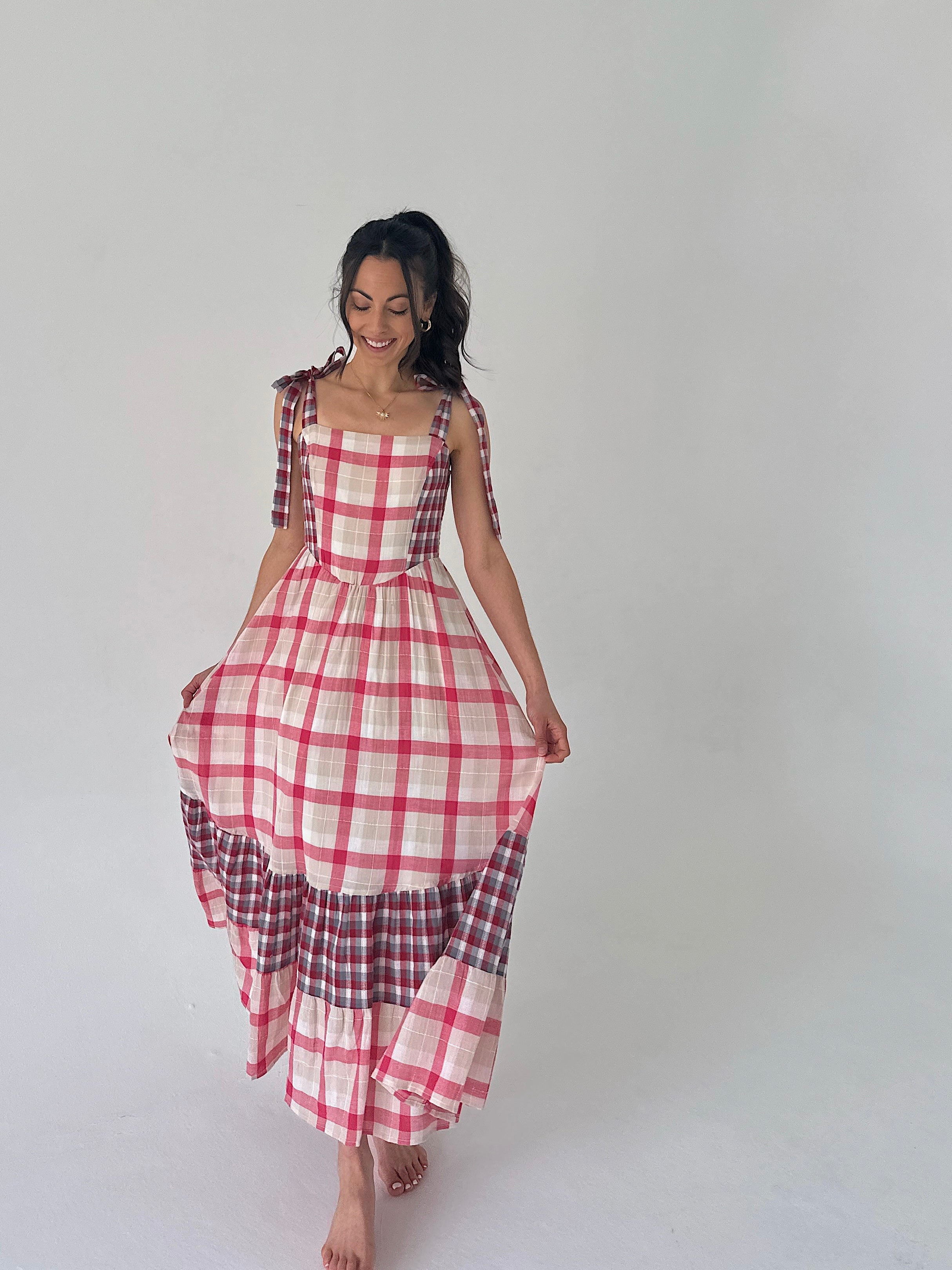 Woman wearing a red and white checkered dress on a plain background