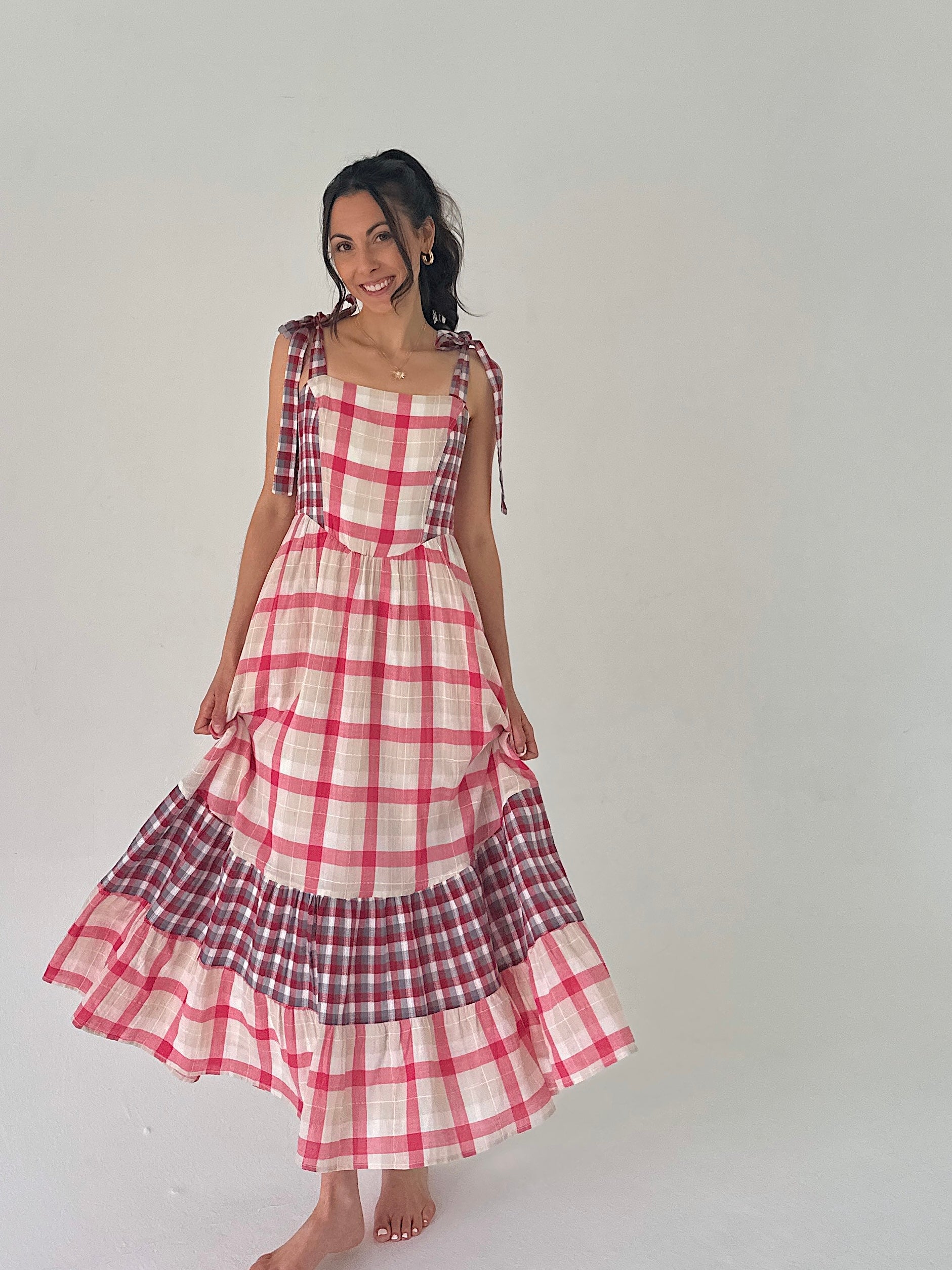 Woman wearing a red and white checkered dress on a plain background