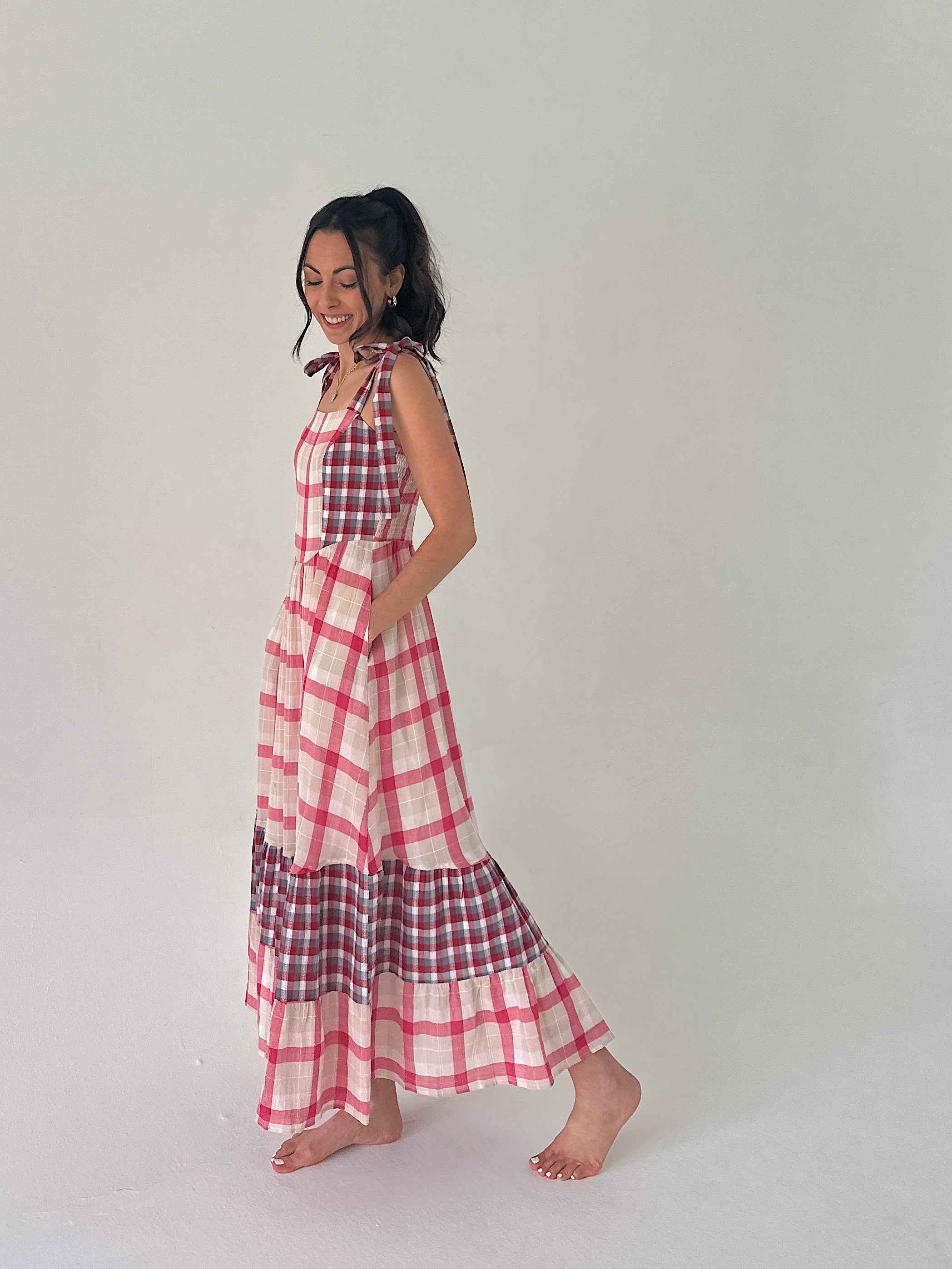 Woman wearing a red and white checkered dress on a plain background