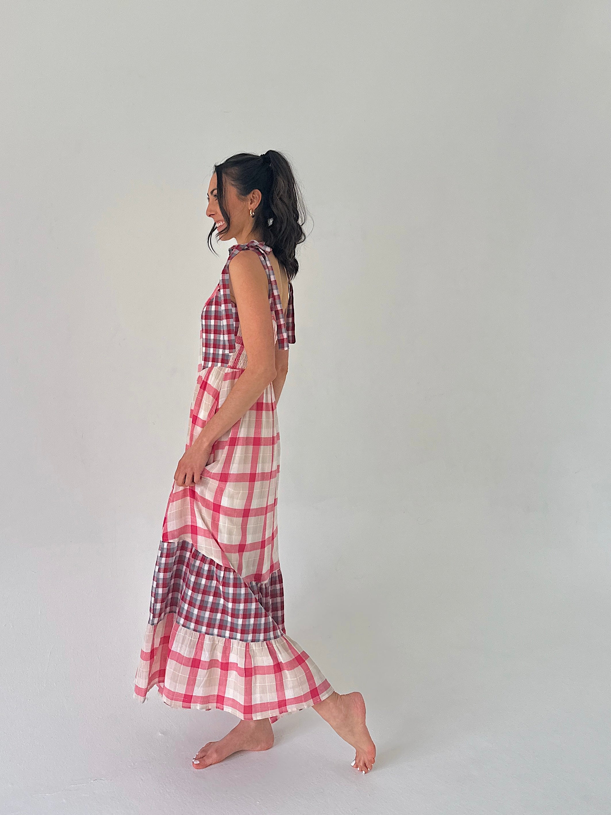 Woman wearing a red and white checkered dress on a plain background