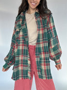 Person wearing a green plaid shirt and red sweatpants against a white background